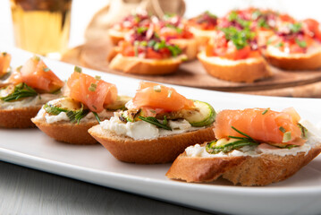 Deliziosi crostini conditi con crema di formaggio, zucchine e salmone affumicato, antipasti italiani 