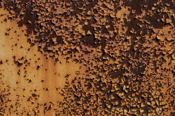 Textured surface of peeling paint on metal, featuring a gradient from brown to yellow with cracked patterns, symbolizing decay and aging