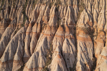 Aerial view above the Red Ravine / Rapa Rosie geological reserve with rocky appearance in the mountainside, in Transylvania, Romania.	
