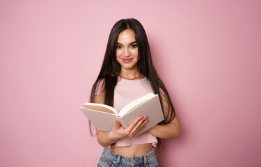 Young woman smile, hold opened book, isolated on pink color background