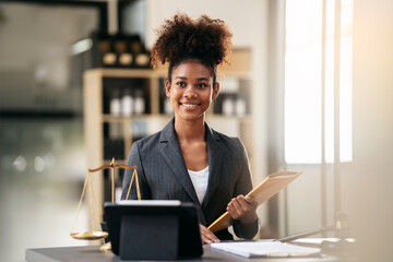 African american lawyer woman in suit holding envelope of business contract while sitting to working