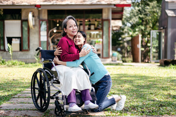 Senior on wheelchair and daughter family concept, Young asian woman smiling and hugging with disabled