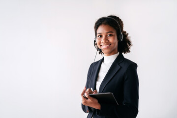 A woman in a business suit is smiling and holding a tablet