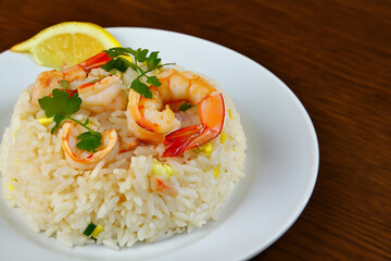 rice with seafood. on a white plate lies a handful of boiled rice with seafood and lemon slices, close-up top view, food concept