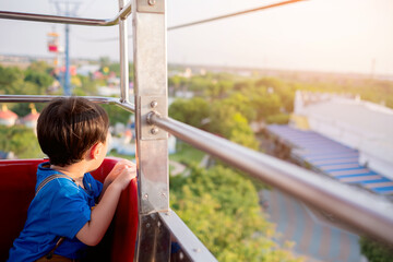 Obraz premium Cute little boy enjoying ride in cable car with parent. Children have activities with Family concept. Selective focus. Copy space.