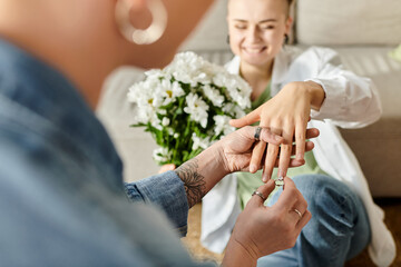 A touching moment as one woman lovingly places a ring on another one finger, symbolizing their...