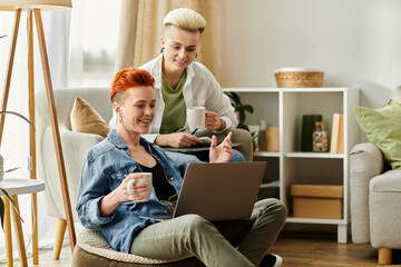 Two young women with short hair sit on a couch, engrossed in using a laptop together.