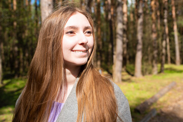 Portrait of a beautiful teenage girl, young woman with long hair in the park