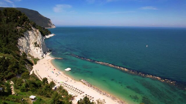 Spiaggia del Frate aerial beach view. Riviera del Conero Marche Italy. White rocks. 4K drone overflight. Turquoise Adriatic sea and green cliffs. Scenic summer coastline. Ancona.