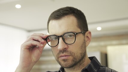 Amazed man in glasses looking at camera, feeling shocked, posing at home