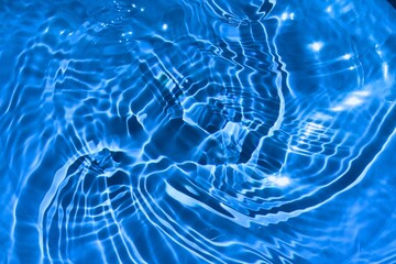 Blue clear calm water surface texture with splashes and bubbles. Trendy abstract summer nature background