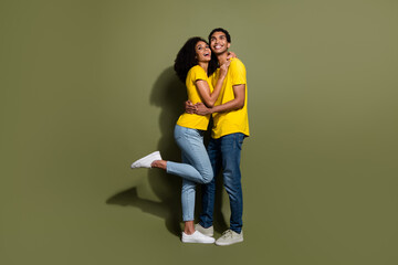 Full body portrait of two nice people cuddle look empty space wear t-shirt isolated on khaki color...