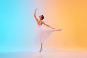 Fototapeta na wymiar Dynamic photo of ballet dancer extends her arm elegantly dressed in pale tutu in neon light against blue-orange gradient background. Concept of art, movement, classical and modern fusion, beauty. Ad