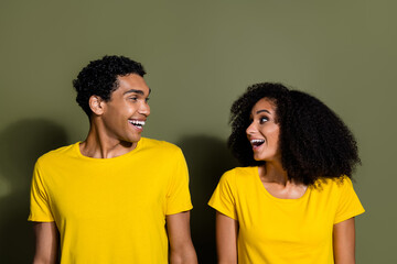 Portrait of two nice people look each other wear t-shirt isolated on khaki color background