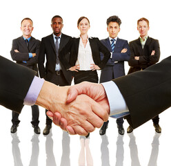 Geschäftsleute beim Handschlag vor Business Team als Konzept