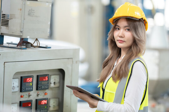 Through collaboration and innovation, the Asian female engineer enhanced the industrial factory's position in the global business arena, integrating tablet technology for the company. - Powered by Adobe