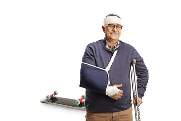 Mature man with a broken arm and bandage on head leaning on a crutch, skateboard fall injury
