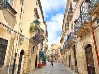 Photo of a traditional picturesque alleyway in Ortigia, Syracuse, Italy. Syracuse is a historic city on the Italian island of Sicily, the capital of the Italian province of Syracuse.