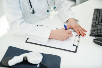 Compassionate physician recording patient notes during a bright daytime clinic consultation
