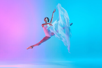 Ballet dancer performs jumping split in motion with flowing white cloth in neon light against vivid gradient background. Concept of art, movement, classical and modern fusion, beauty and fashion. Ad