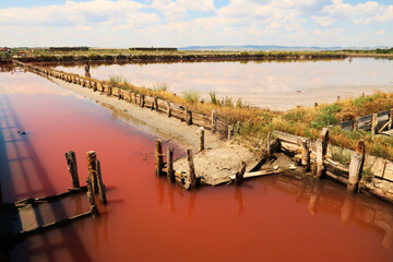 Board walks running through the pools of the Burgas Salt Pans, filled with pink water, the clouds...