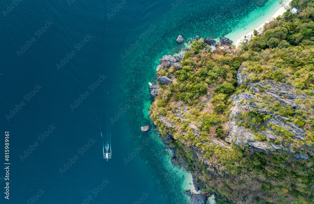 Wall mural aerial top view of a traditional philippine boat sails in sea with clear and turquoise water on the 