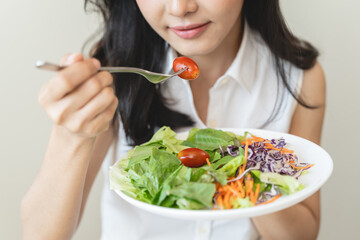 Diet, Dieting asian young woman or girl use fork at broccoli on mix vegetables, green salad bowl,...