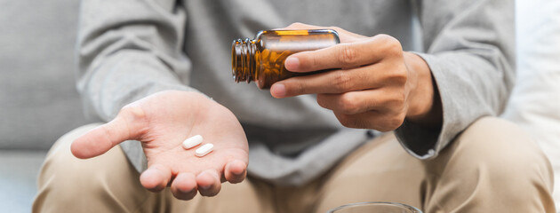 Close-up a medicine tablet in young man hand taking painkiller
