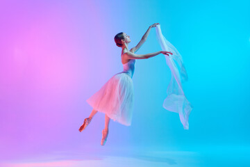 Dynamic portrait of young ballerina dancing with fabric in neon light against vivid gradient background. Elegance. Concept of art, movement, classical and modern fusion, beauty and fashion. Ad © master1305