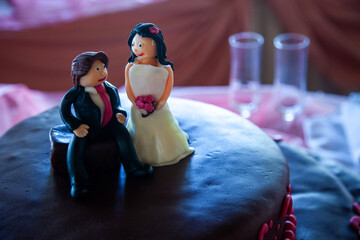 Delicious chocolate wedding cake adorned with adorable bride and groom figurines