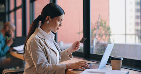 Woman, coffee shop and credit card on laptop, online shopping and happy with purchase. Internet,...