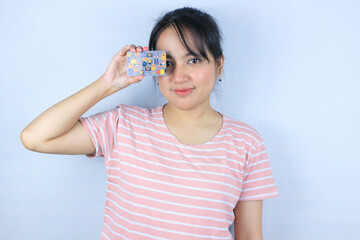 Smiling face expression of beautiful asian young woman showing credit card on white background