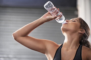 Gym, woman and drinking water bottle for hydration from training for health or cardio with thirst....