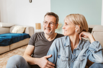Smiling senior couple spending quality time together in their cozy living room, radiating happiness and love.