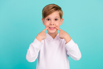 Photo of positive boy showing white teeth medical therapy dental clinic isolated cyan color background