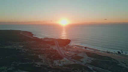 Drone view coast sunrise greeting beach with golden light. Serene ocean aerial