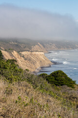 a foggy morning on the coast of Point Reyes national sea shore area. With a beautiful view over the sandstone mountains that forms the iconic coastline
