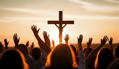 Lot of Christian worshipers raising hands up in the air for the cross in background in golden hour.