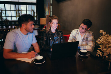 Three friends studying in a cozy cafe during evening