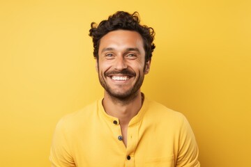 Obraz premium Portrait of a grinning man in his 30s smiling at the camera in front of soft yellow background