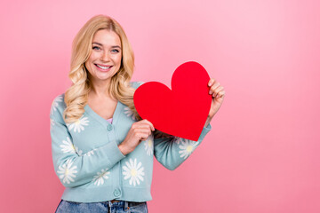Photo of satisfied kind woman with wavy hairdo dressed print cardigan demonstrate big red heart...