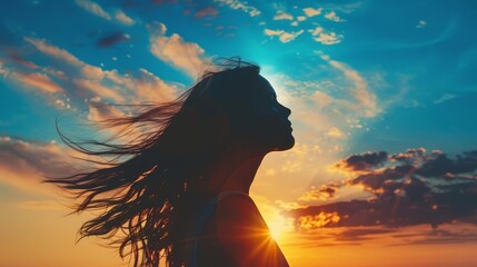 silhouette of woman with flowing hair against radiant sunset sky inspirational concept photo