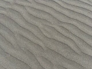 Gray volcanic sand dunes after windy weather and breeze in El Medano, Tenerife, Canary Islands, Spain 