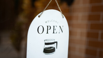 An open sign of the coffee shop that hanging at the entrance door. Sign and symbol for business using object, close-up.