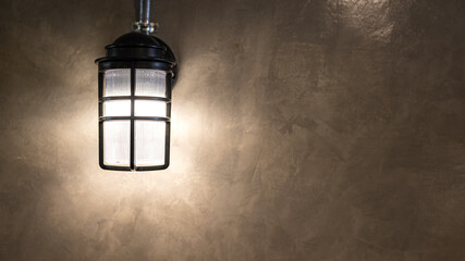 An industrial designed wall lighting lamp is glowing in warm light shade. Interior decoration and...