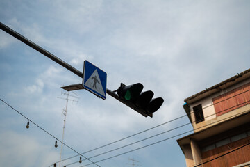 Pedestrian traffic crossing light in green signal at the urban city road. Transportation safety sign object, selective focus.