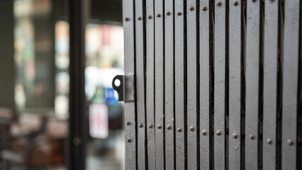 Classic style sliding metal fence gate, it using for cover the glass wall inside. Building place object photo, close-up and selective focus.