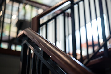Close-up at building stairway banister wooden handrail in vintage style. Interior building and object photo, selective focus.