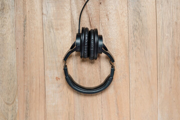 Black headphones isolated on wooden background