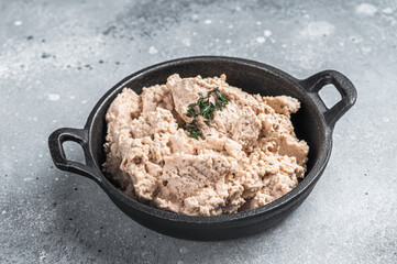 Cod liver Spread with oil in a skillet. Gray background. Top view. Copy space